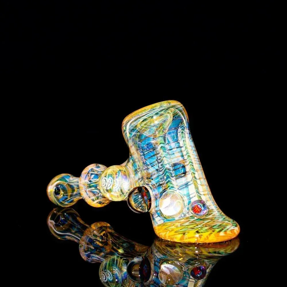Heady glass hammer pipe with intricate multicolored patterns on black background