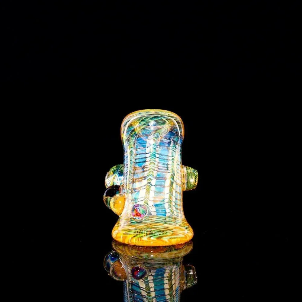 Colorful heady glass pipe with intricate patterns displayed on a reflective black surface
