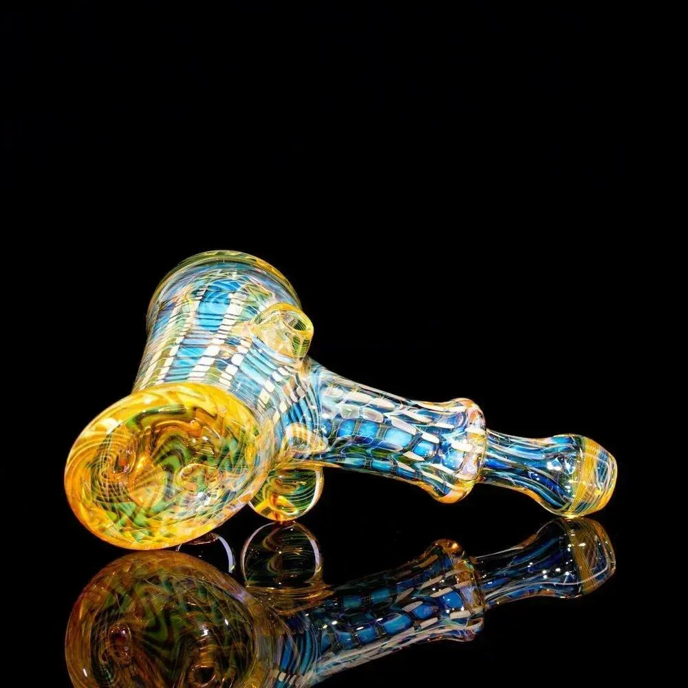 Colorful glass hammer pipe with intricate blue and yellow pattern on black background