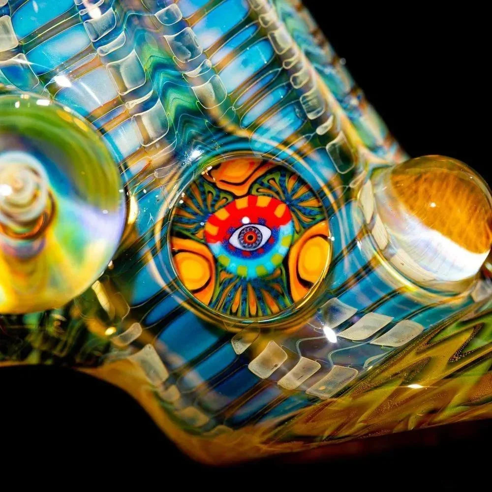 Close-up of heady glass art pipe with vibrant psychedelic patterns and a colorful eye design