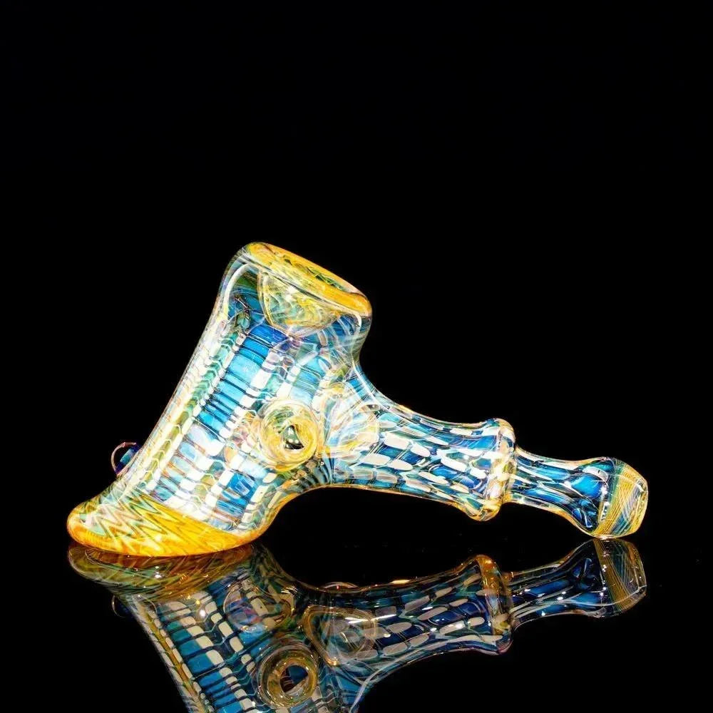 Colorful glass hand pipe with blue and yellow accents on a black reflective surface