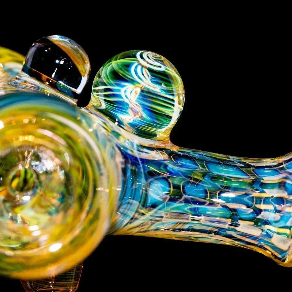 Close-up of intricate multicolor heady glass pipe with swirling patterns on black background.