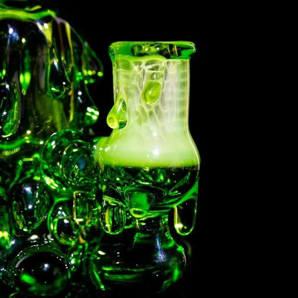 Green artisan glass rig with droplet details on a black background, smokeware accessory