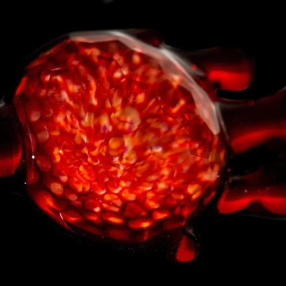 Red glass pendant with honeycomb texture and pomegranate coloring on black background