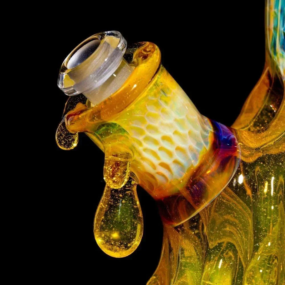 Close-up of a colorful heady glass water pipe with honeycomb pattern and drip accents