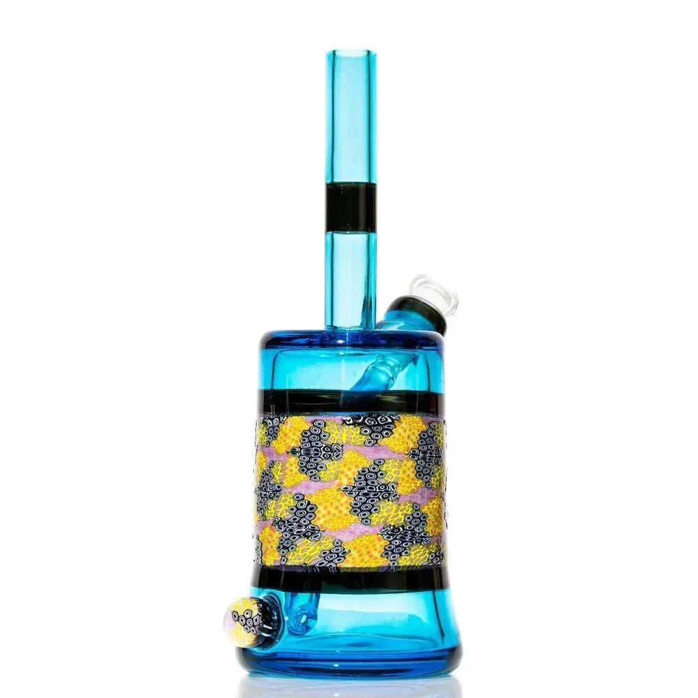 Blue glass water pipe with colorful murrine pattern and cylindrical chamber on white background.