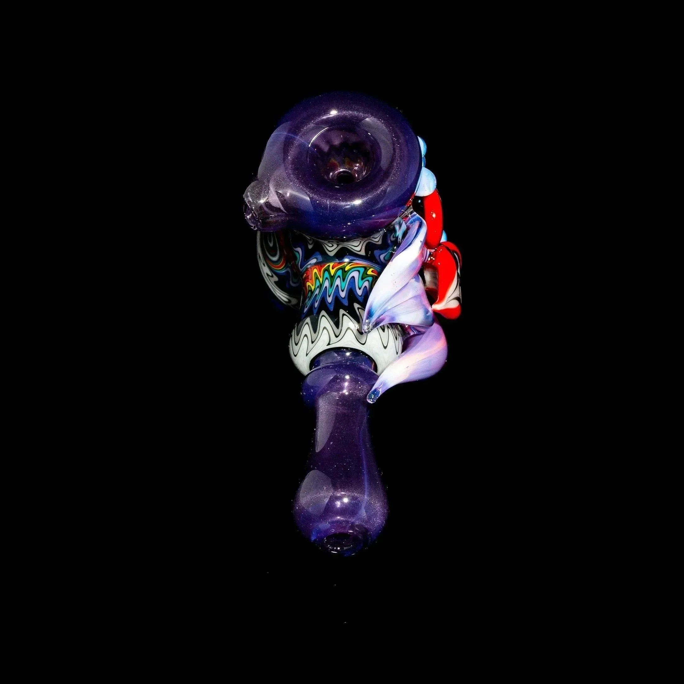 Purple glass hand pipe with intricate linework and flower design on black background