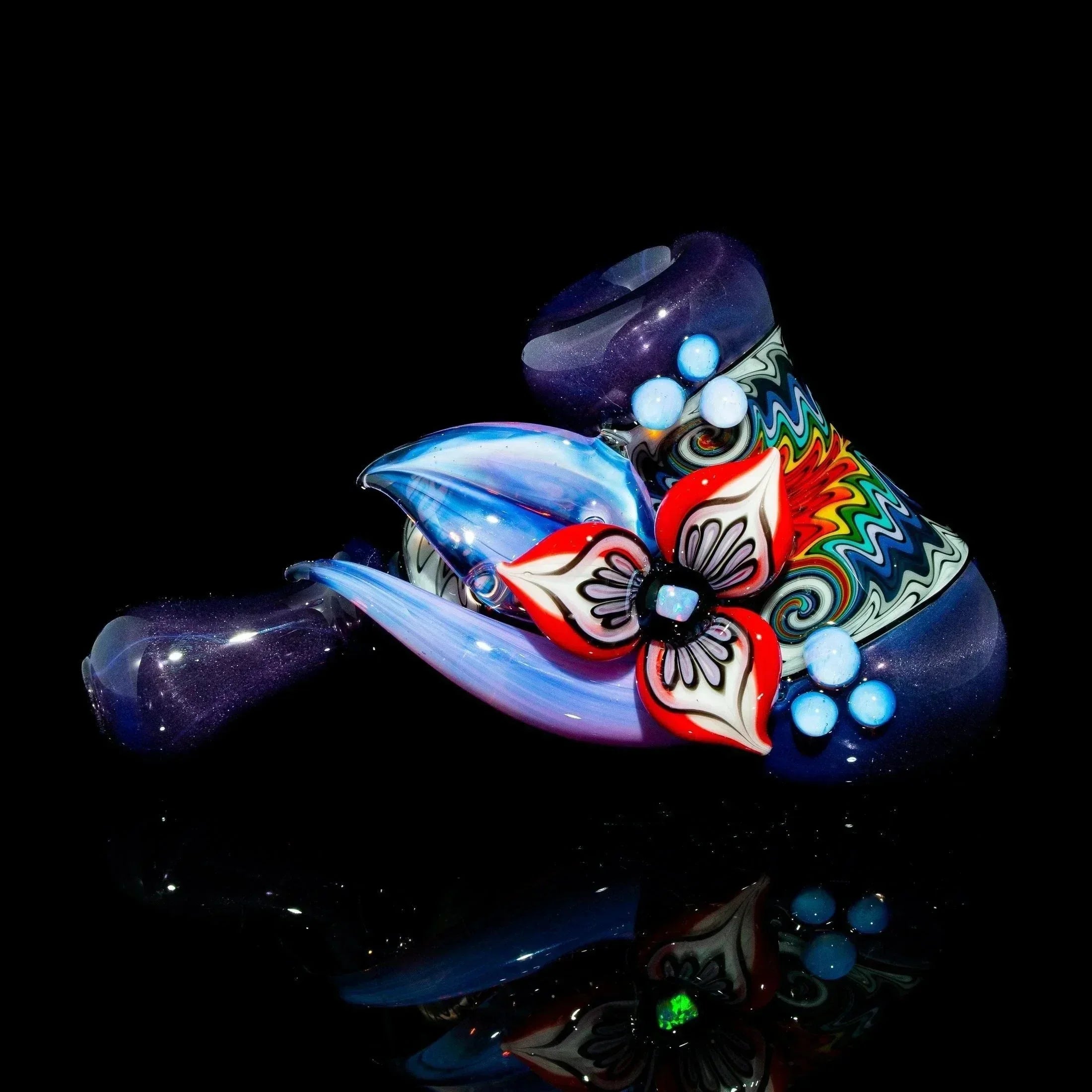 Purple glass hammer pipe with detailed flower design and colorful linework, on black background.