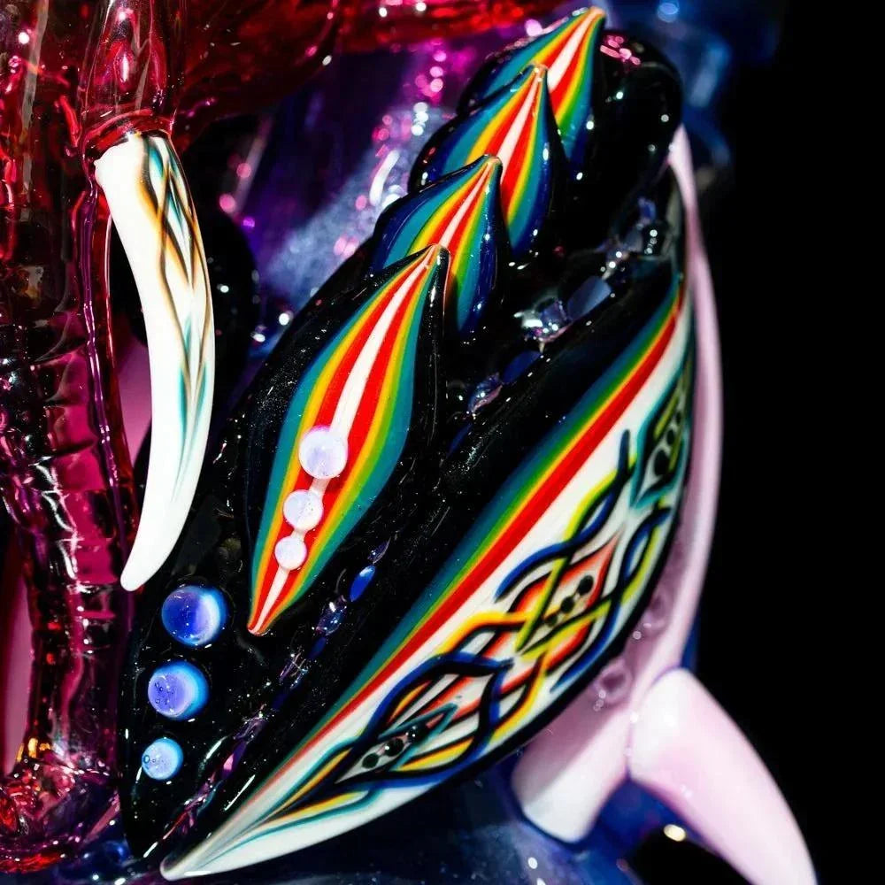 Close-up of colorful, intricate borosilicate glass art with rainbow accents and detailed patterns.