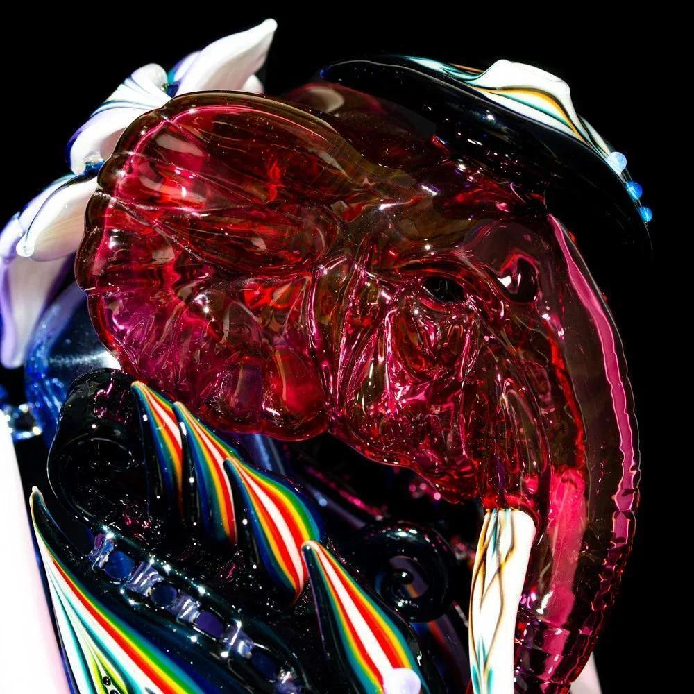Colorful glass elephant recycler with vibrant patterns and floral accents against black background