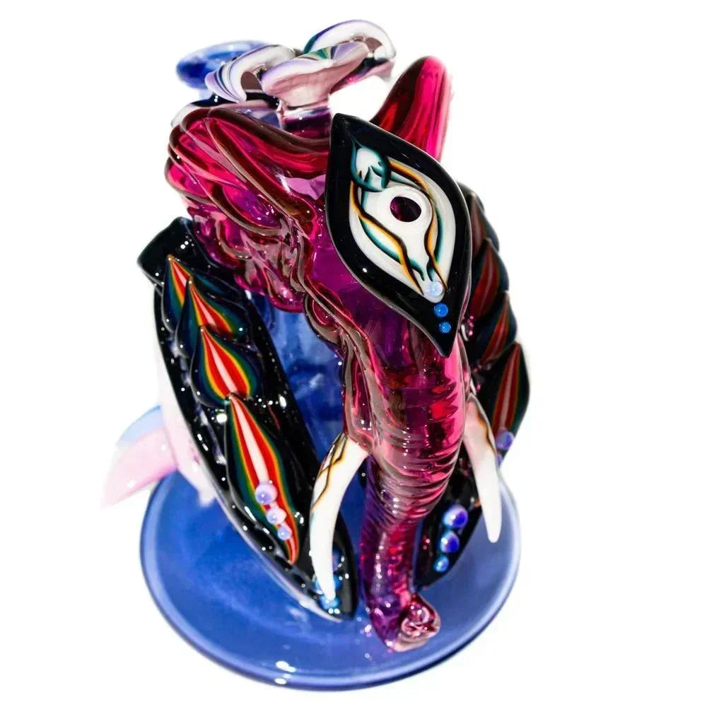 Colorful elephant-shaped glass recycler art pipe with detailed patterns on a blue base