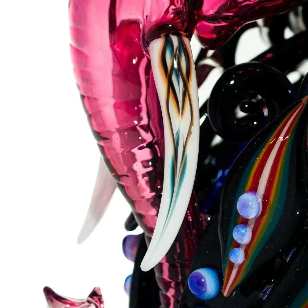 Close-up of colorful glass elephant recycler with intricate tusk and vibrant accents