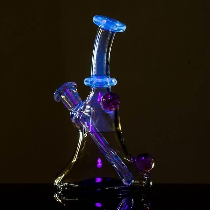 Colorful glass bong with blue and purple accents, featuring a beaker base and percolator for smooth hits.