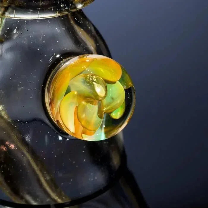 Heady glass bong with intricate amber and green swirls, showcasing artisan craftsmanship.