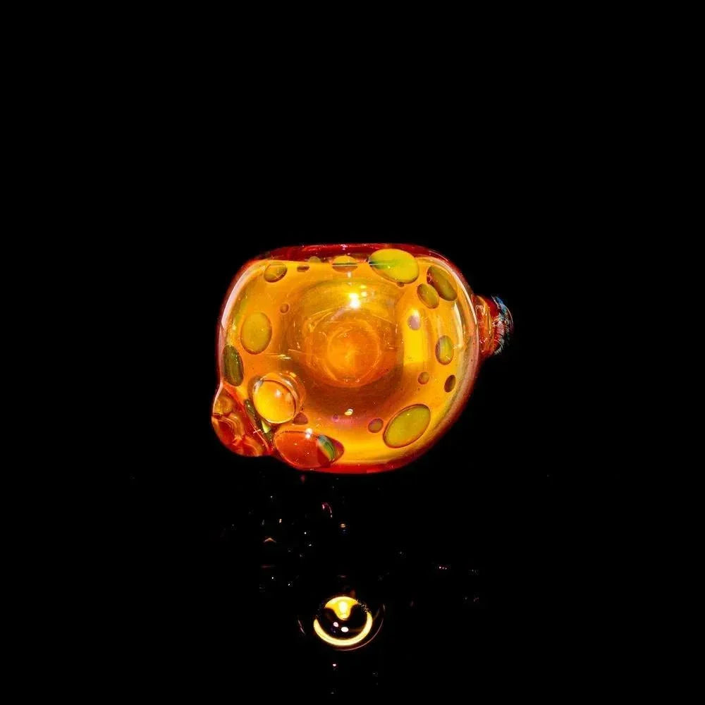 Gold fumed glass spoon pipe with bubble accents on a black background