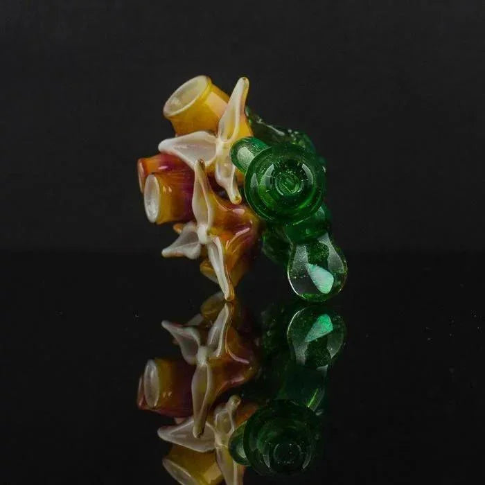 Colorful heady glass pipe with amber, white, and green swirls on black reflective surface