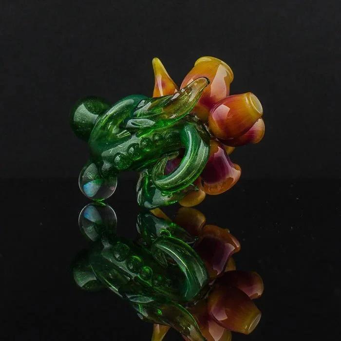 Vibrant green and amber heady glass pipe with floral design, reflective surface
