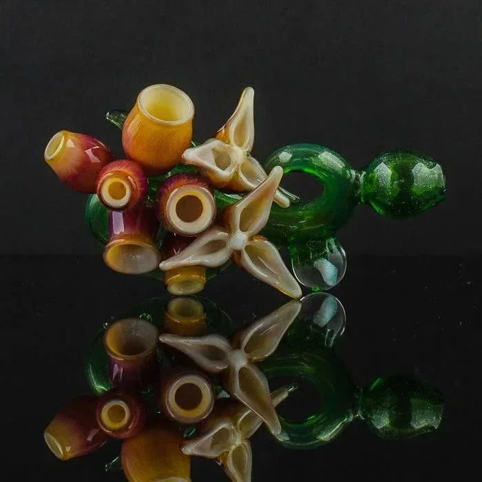 Colorful heady glass pipes with floral designs, reflective surface, vibrant amber green hues