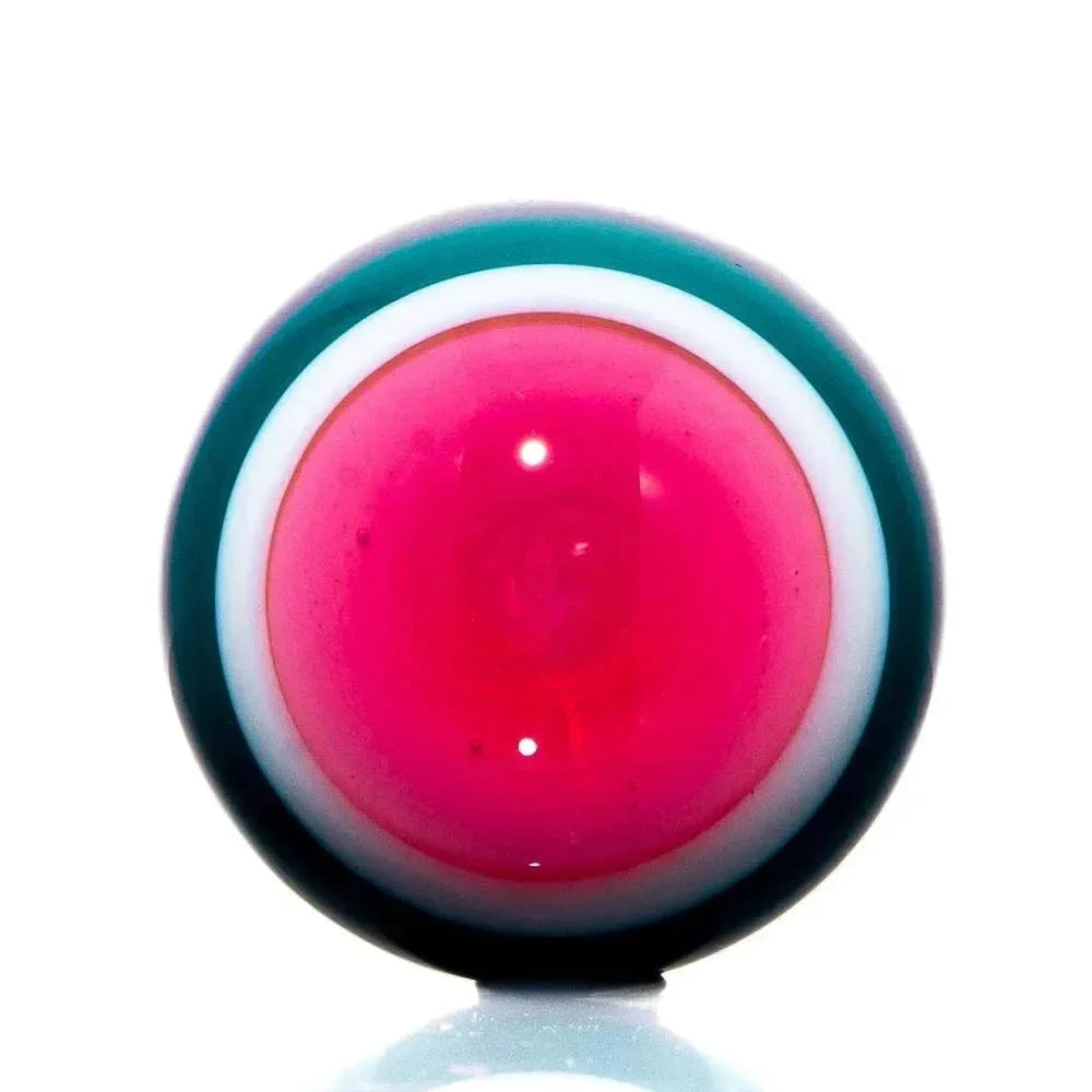 Colorful glass marble with vibrant pink center and teal-white border on white background