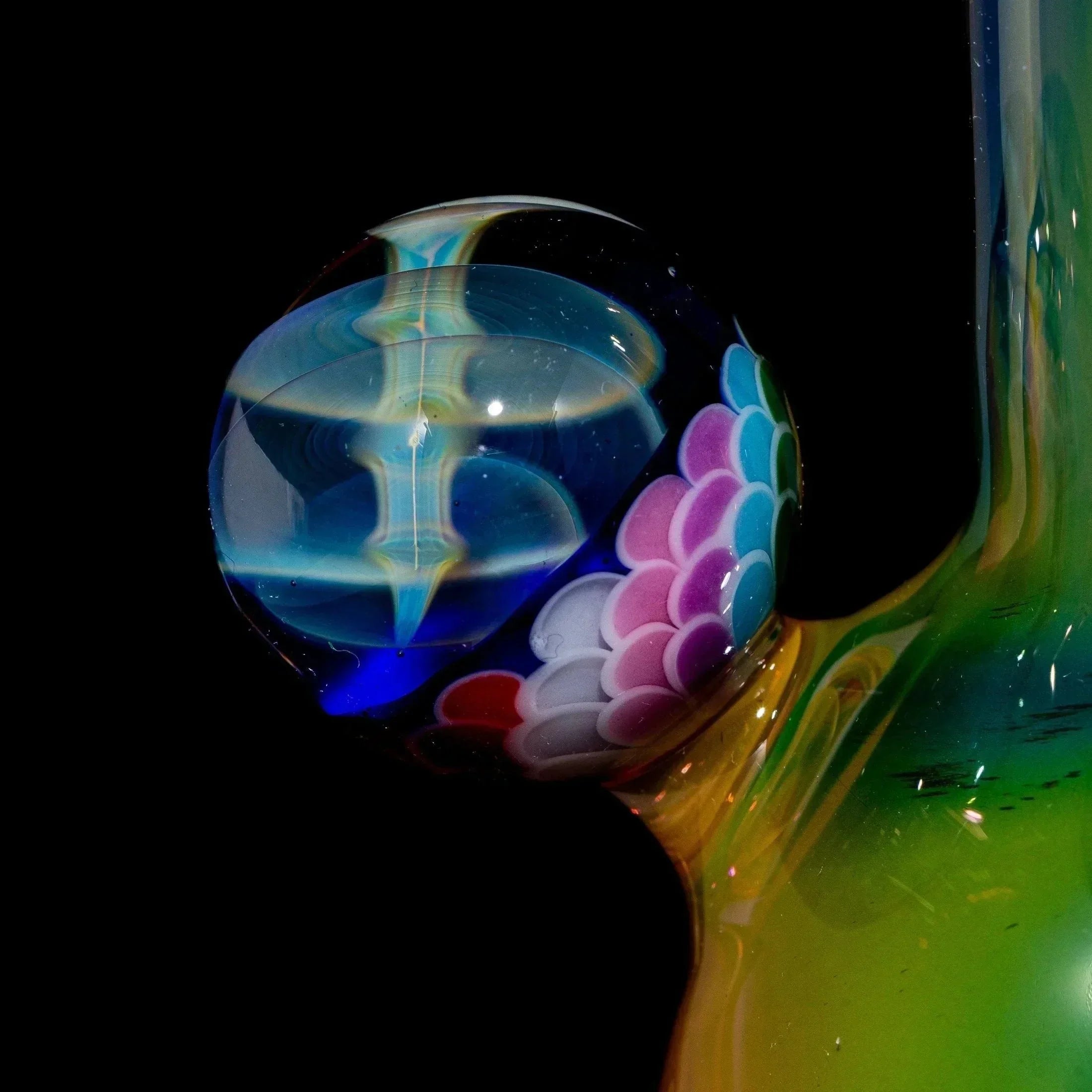 Close-up of a colorful glass rig with intricate rainbow dot and sherlock cap detail