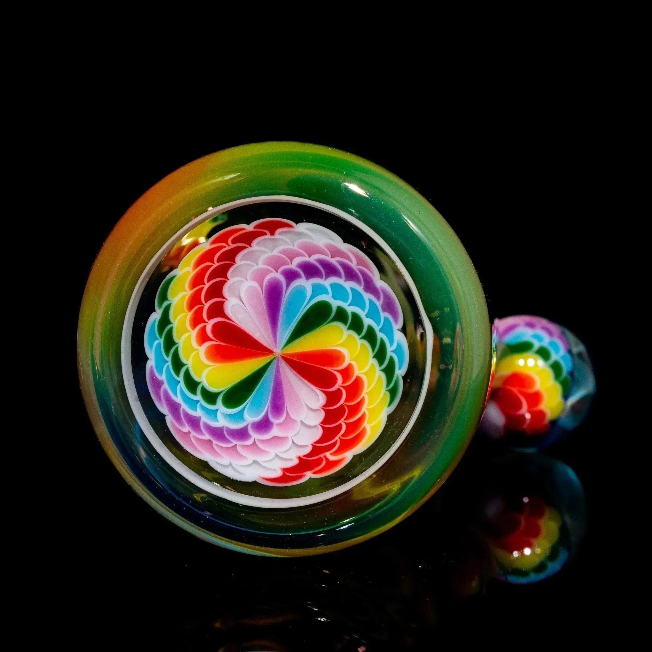 Colorful hand-blown glass rig set with intricate rainbow dotstack pattern on black background