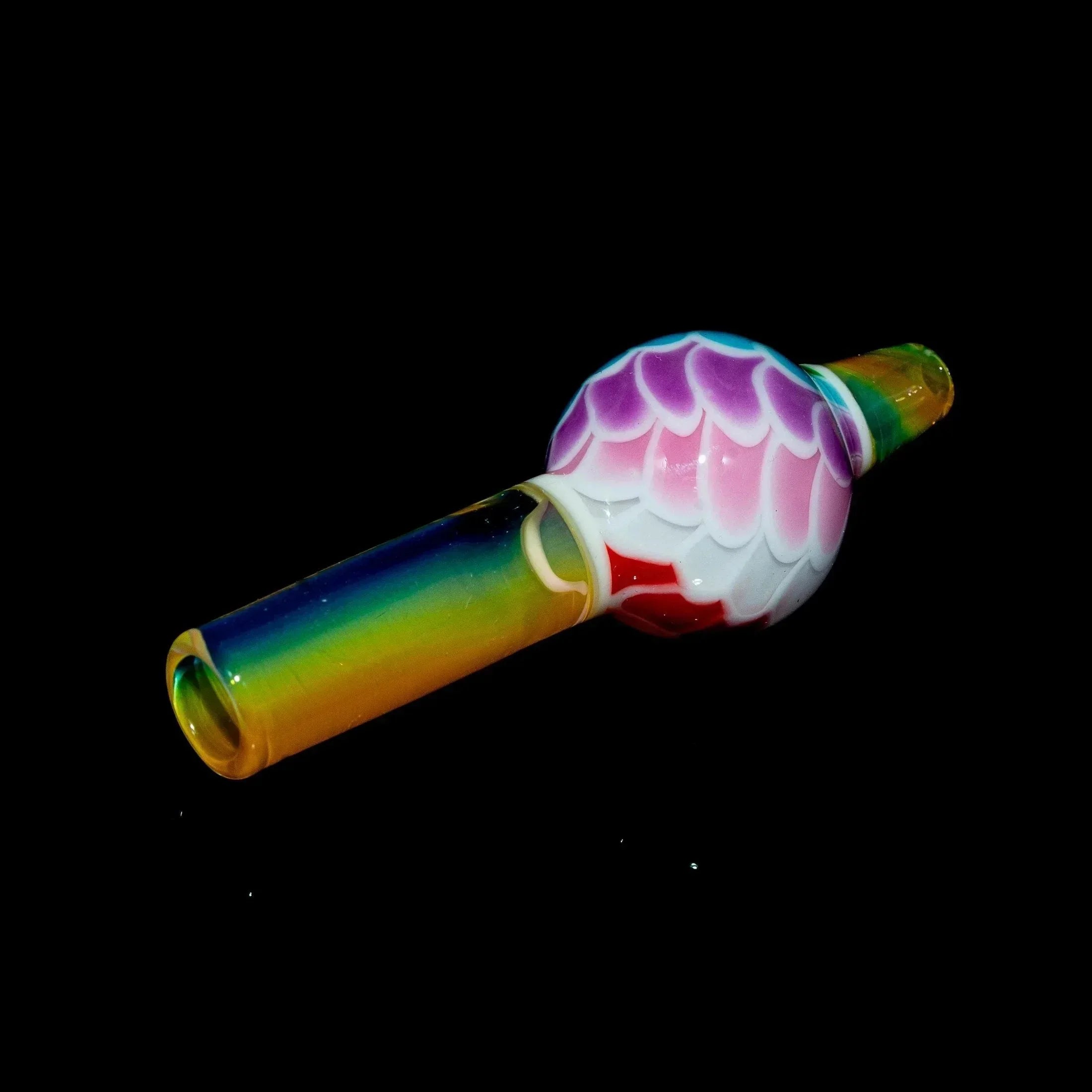 Colorful rainbow glass pipe with pink and white scale design on a black background