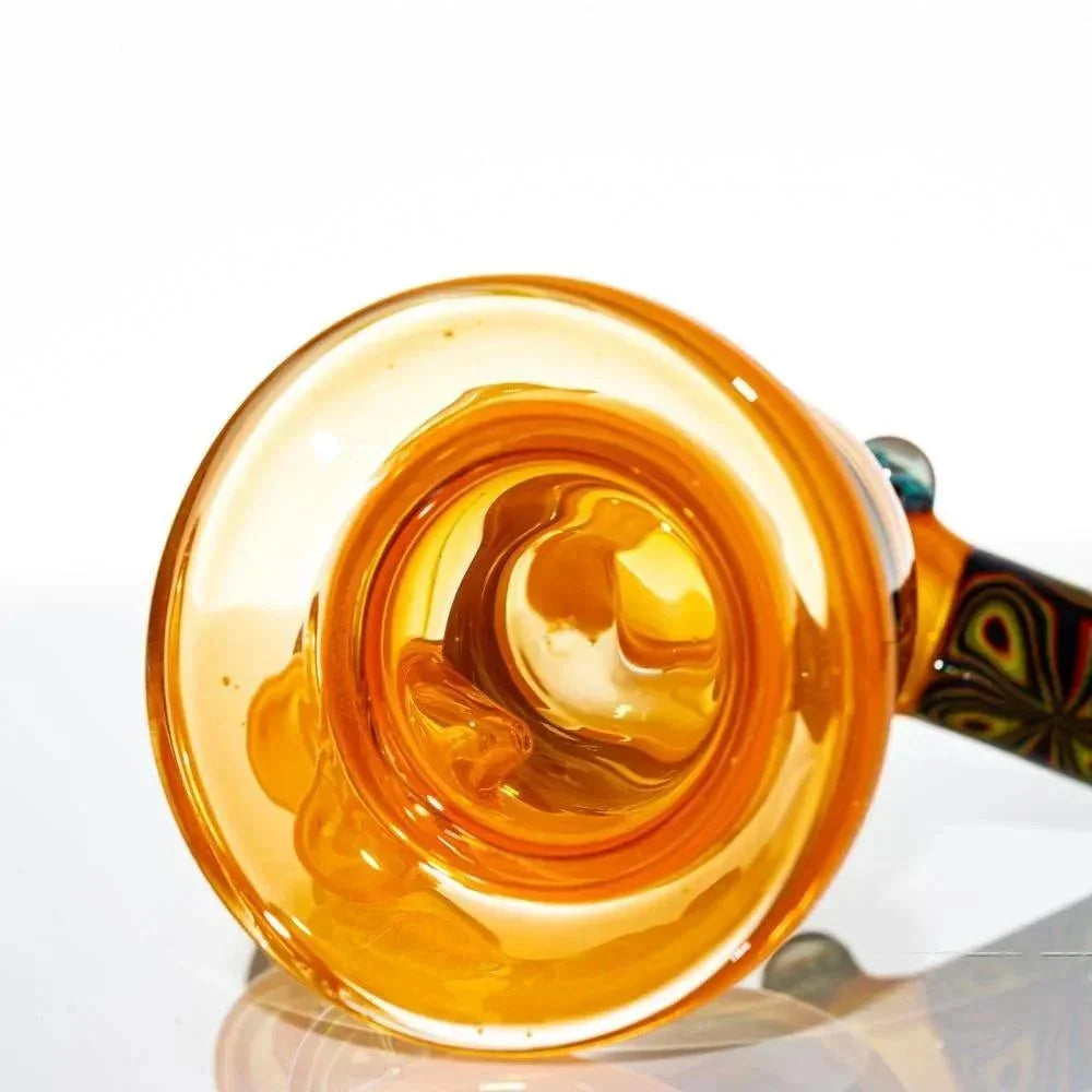 Amber-colored glass mini torch with patterned handle on white background