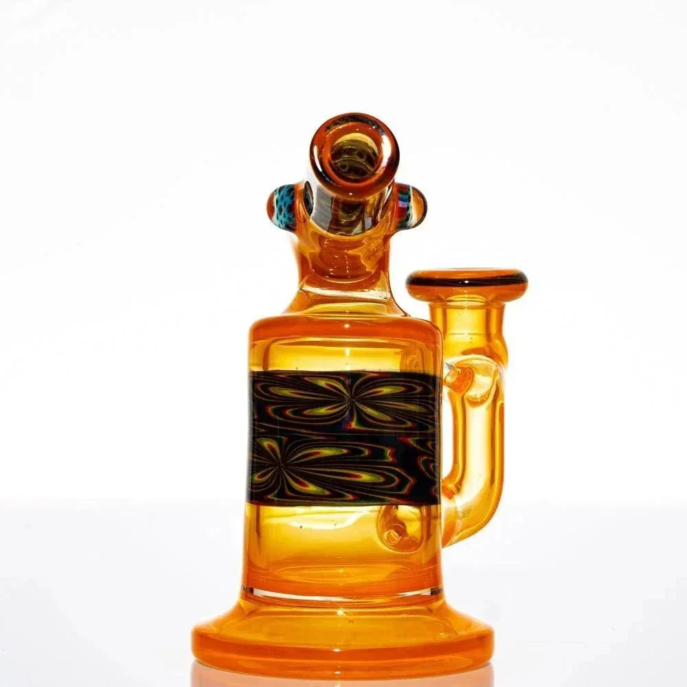 Amber glass mini water pipe with intricate black pattern band, side arm design, clear background