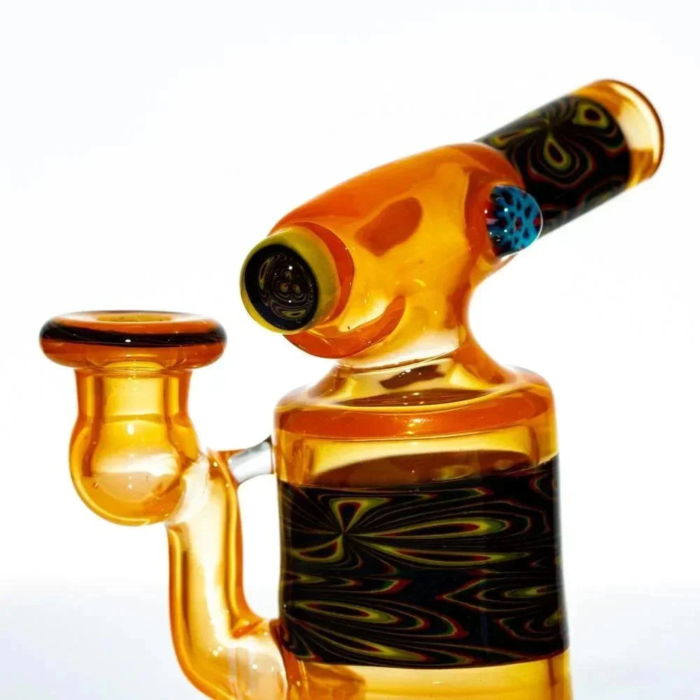 Amber glass mini torch rig with black and yellow swirl accents, side carb and mouthpiece