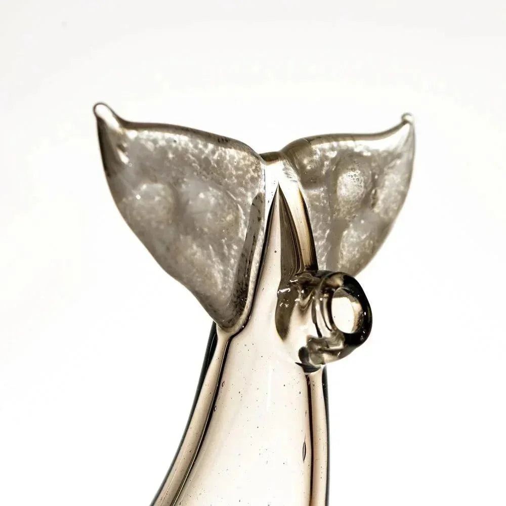Handblown glass sculpture shaped like a whale tail with frosted accents, close-up view