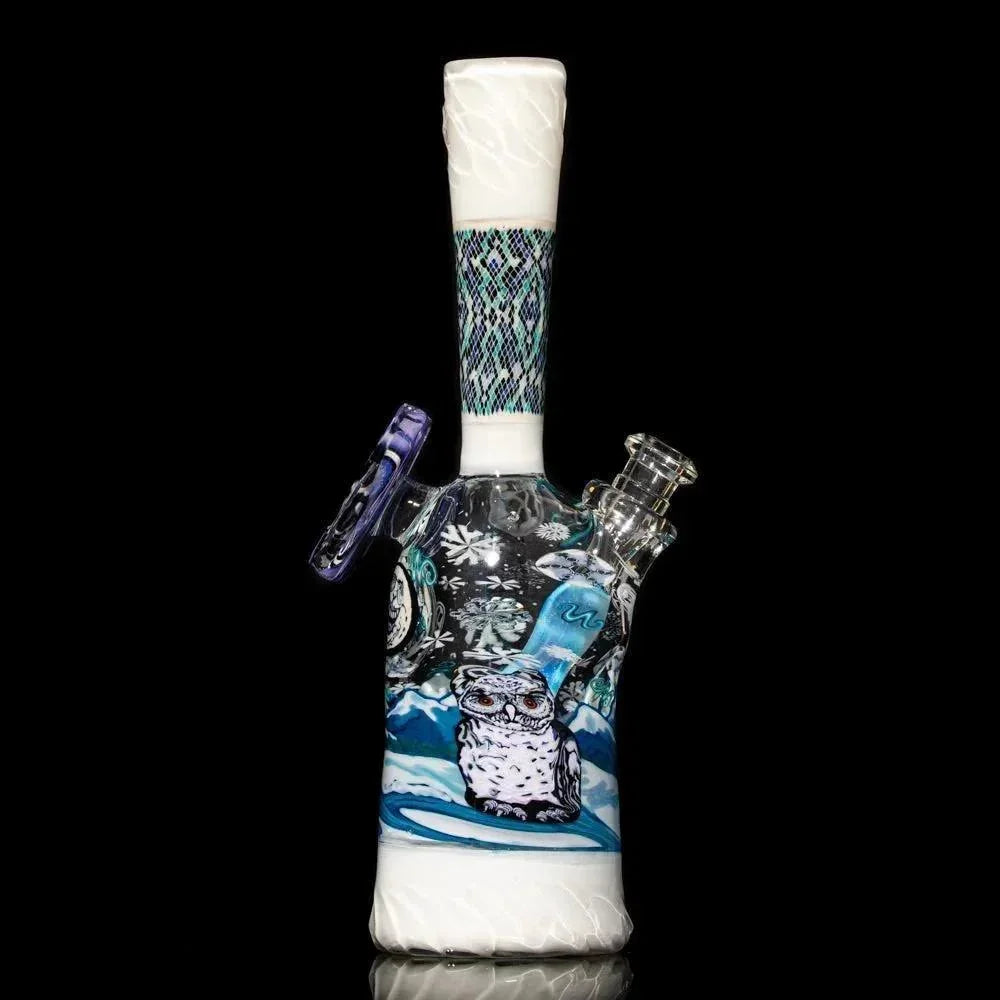 Heady glass water pipe featuring snowy owl art and winter mountain scene on black background