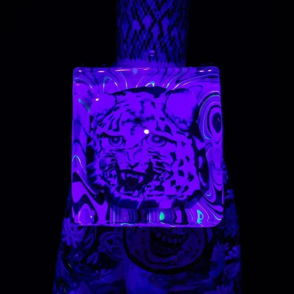 UV reactive glass piece with a detailed snarling leopard face design glowing under blacklight