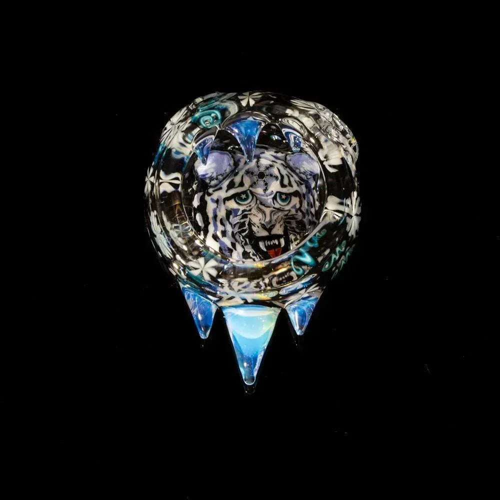 Hand-blown glass art piece with tiger face design and blue crystal spikes on black background