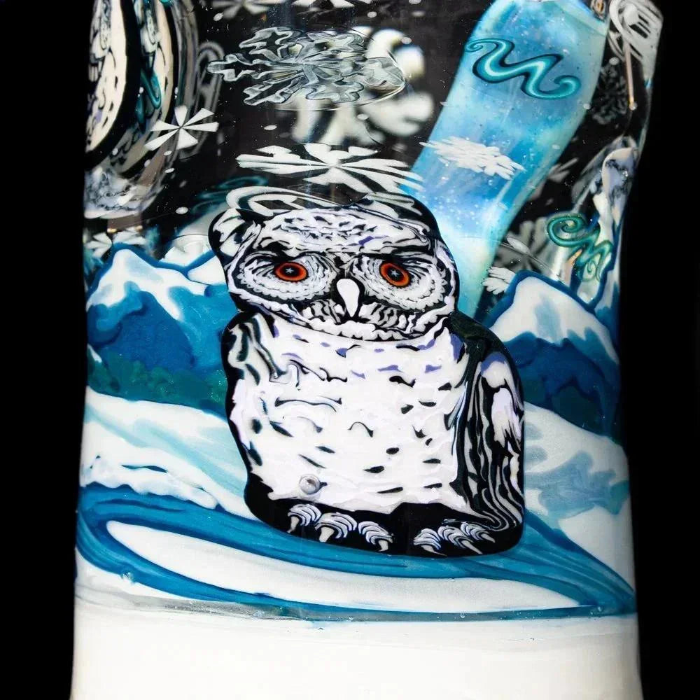 Intricate glass art featuring a detailed snowy owl with red eyes in a winter mountain scene