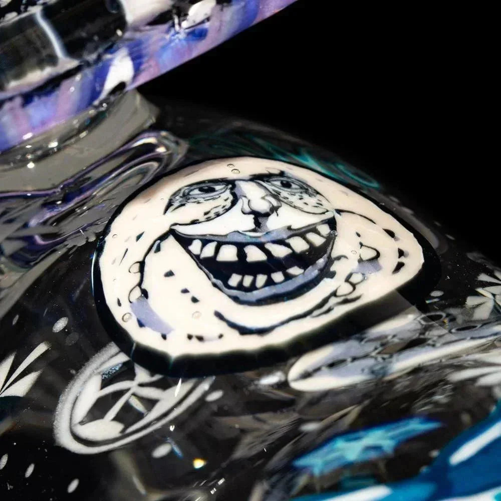 Close-up of artistic glass pipe with a detailed smiling face design and cosmic accents