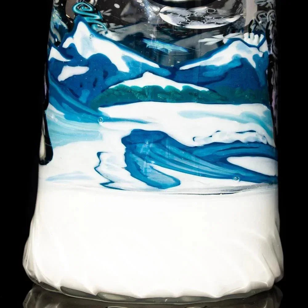 Close-up of artisan glass pipe with swirling blue and white mountain landscape design