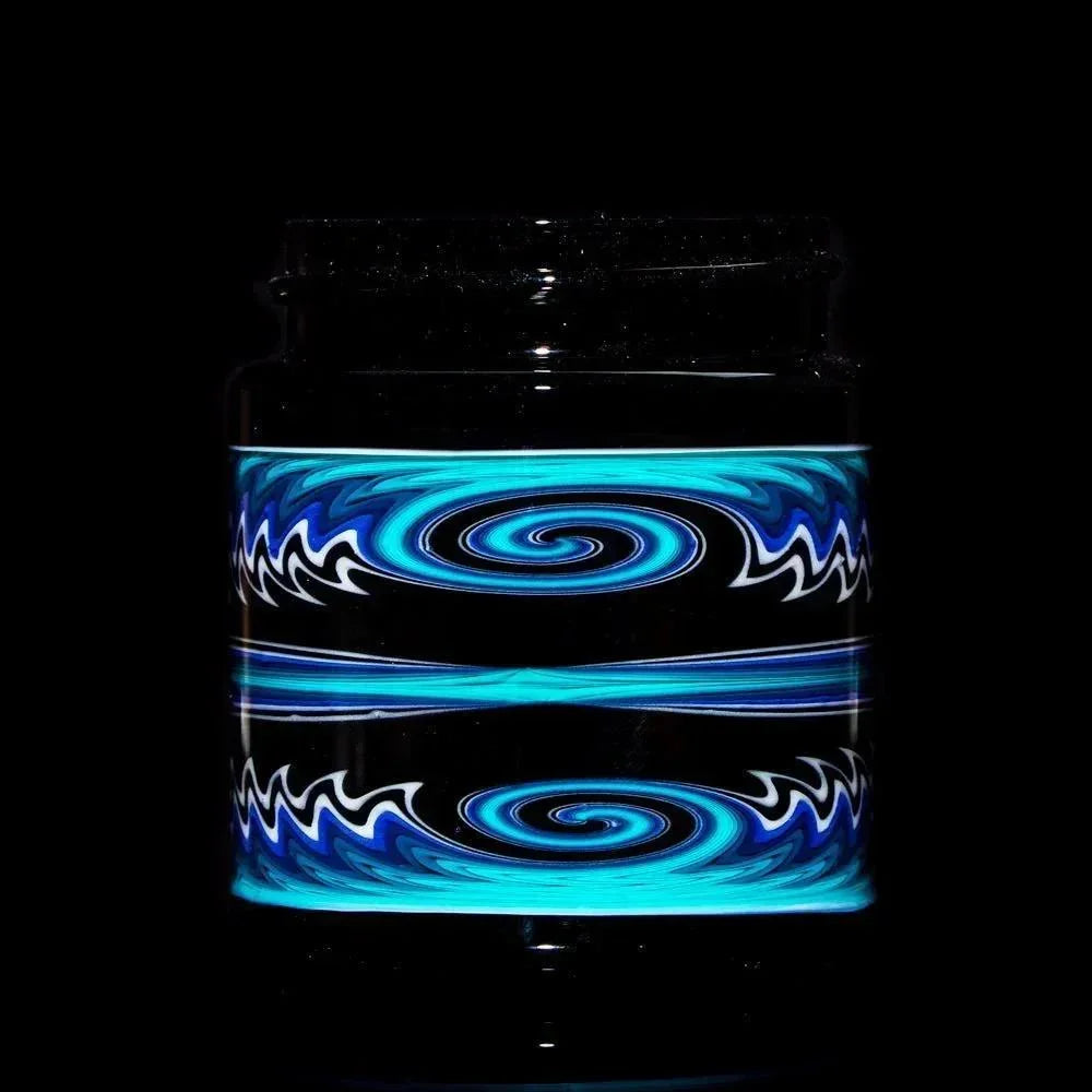 Black glass jar with blue, white, and teal swirl linework pattern on dark background