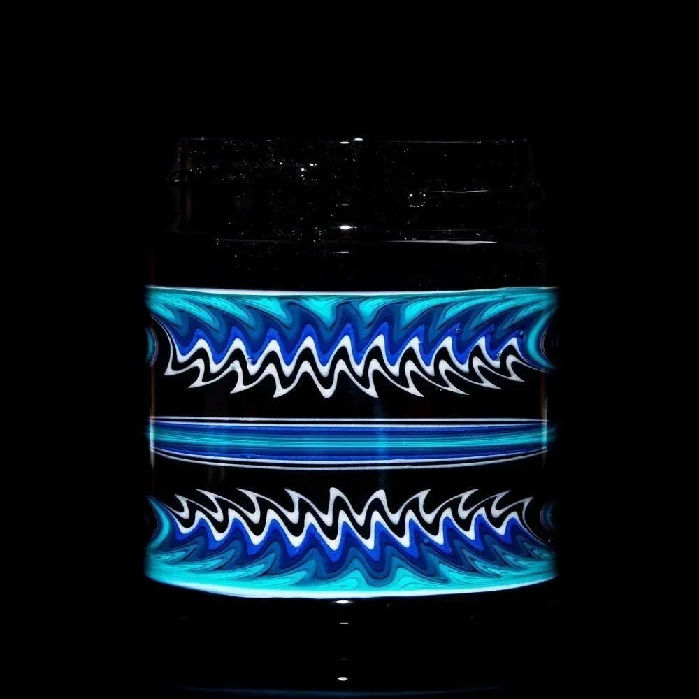 Glass jar with black base and intricate blue linework design, isolated on black background.