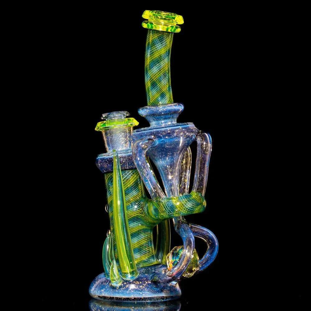 Intricate dichroic glass water pipe with swirling blue and green accents on black background