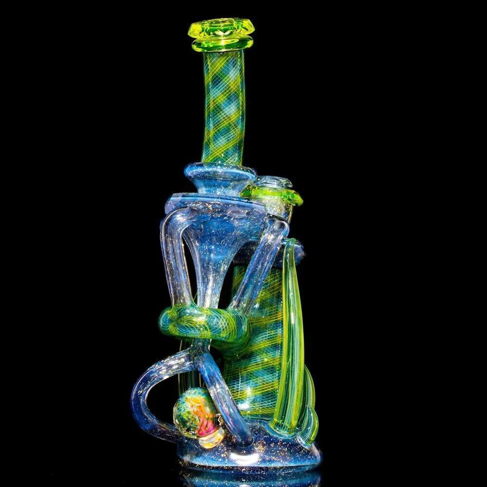 Intricate dichroic glass water pipe with blue, green, and yellow accents on black background