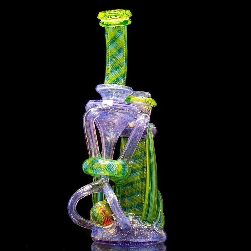 Intricate dichroic glass water pipe with green and yellow patterns on a black background.