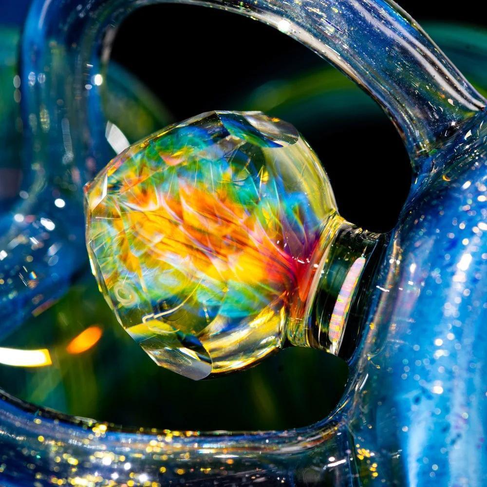 Close-up of colorful dichroic glass attachment on a heady glass water pipe