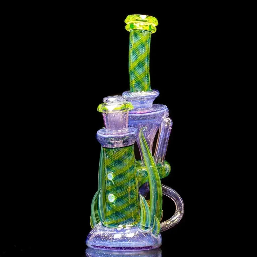 Heady glass recycler rig with green and blue dichroic accents on black background