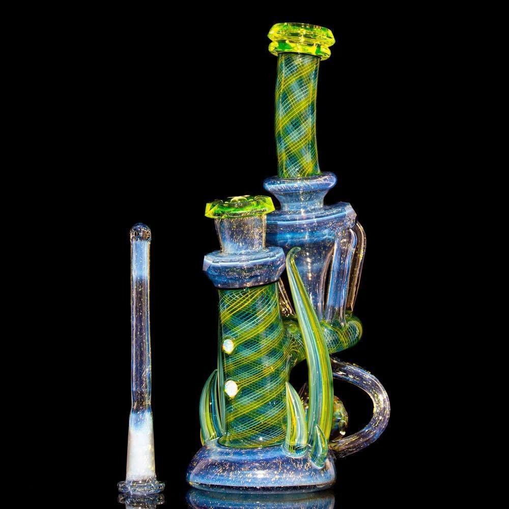 Colorful glass dab rig with dichroic details, green accents, and matching glass wand