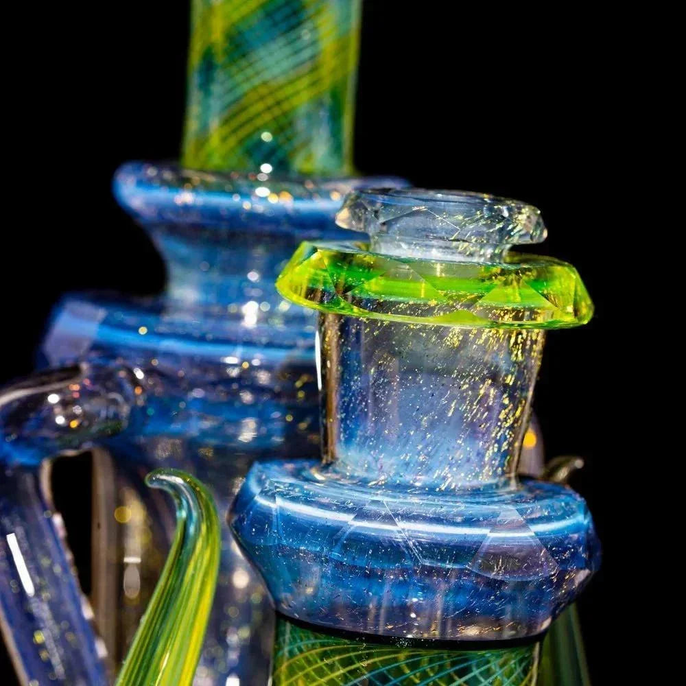 Close-up of colorful heady glass water pipe with blue, green, and yellow accents