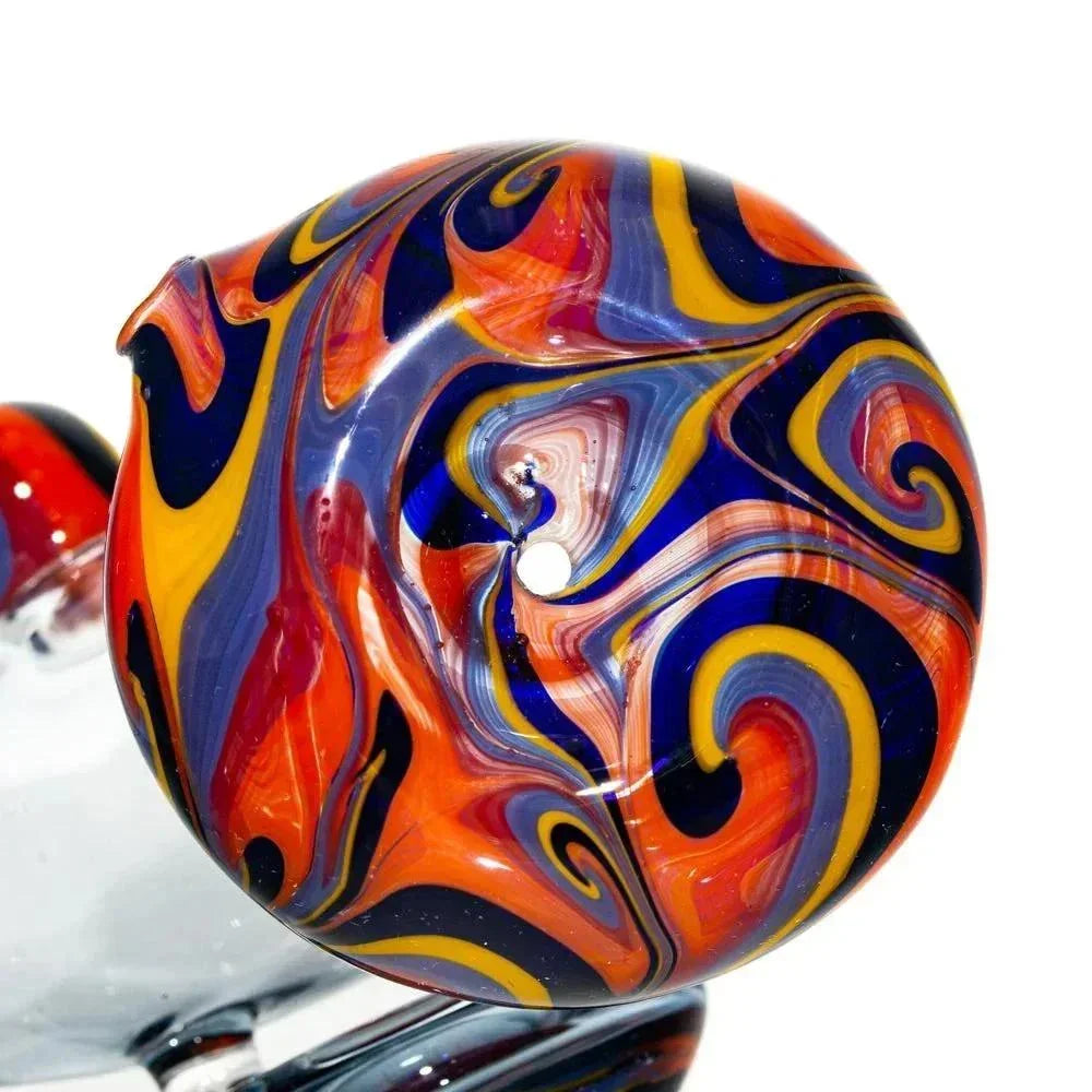 Close-up of a hand-blown glass pipe with vibrant orange, blue, and yellow swirl design