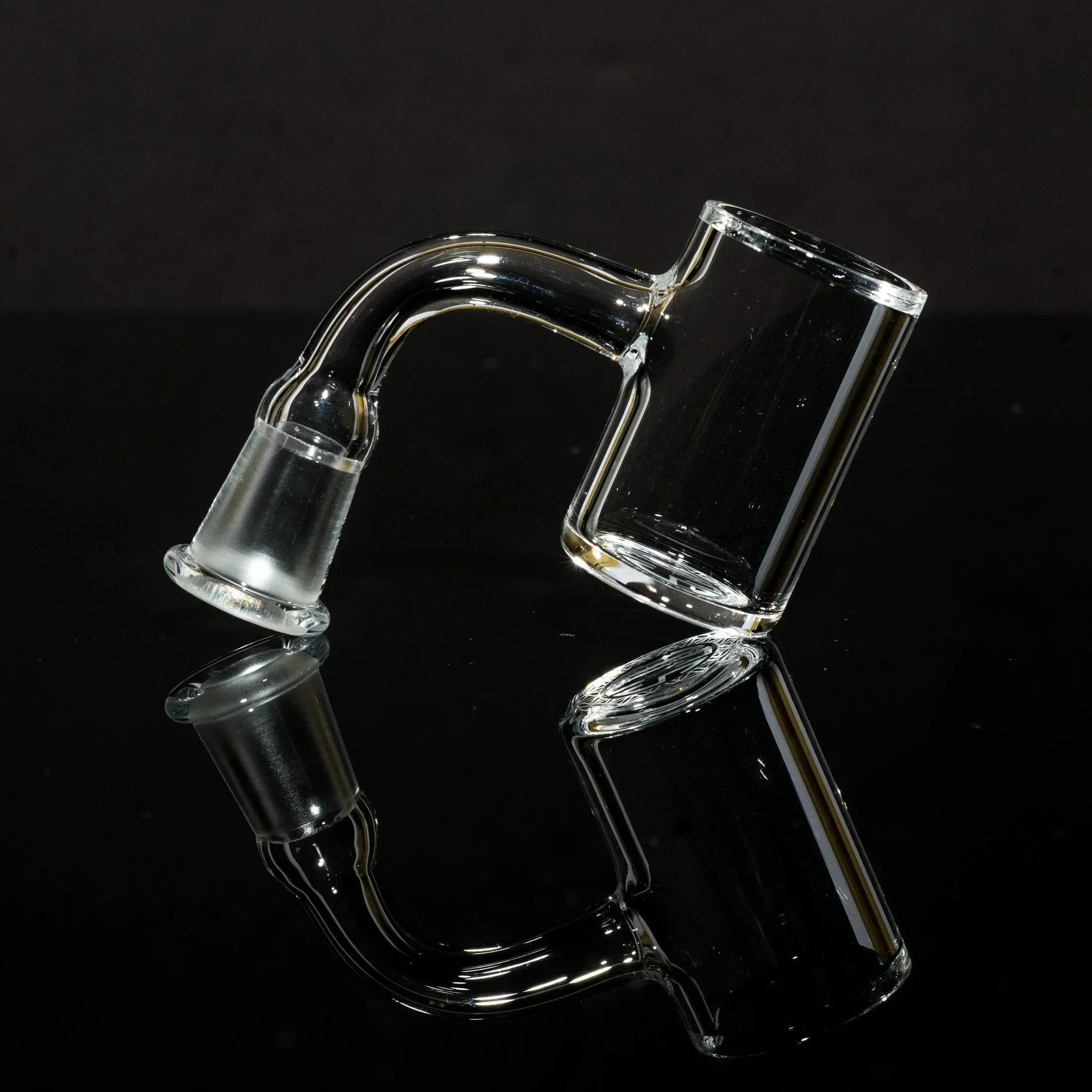 Clear glass bong bowl with curved neck, displayed on reflective black surface for smoke shop accessories