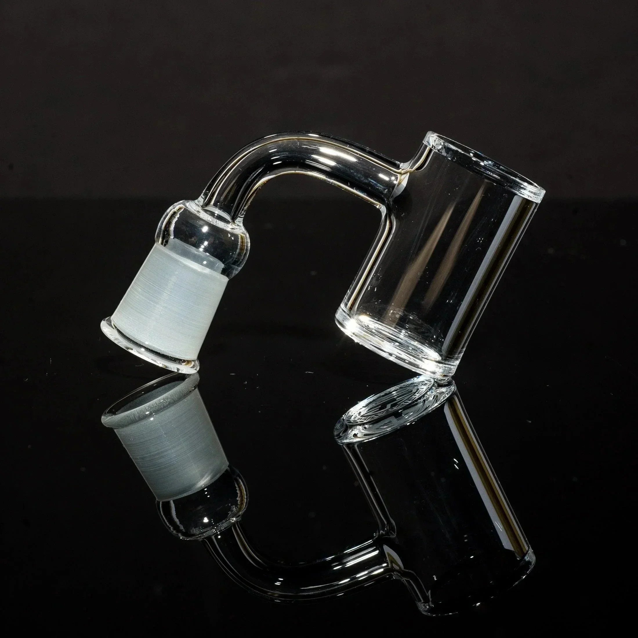 Clear glass dab rig with curved neck and frosted joint, showcased on reflective black surface