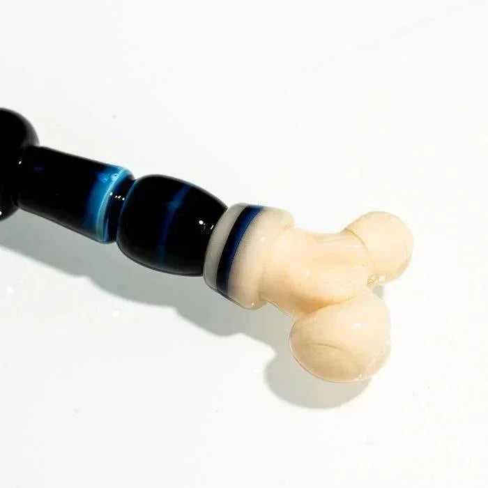 Handblown glass pipe with black blue accents and cream-colored knuckle design
