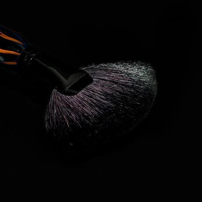 Black glass pipe with glowing orange accents and shimmering purple smoke against dark background